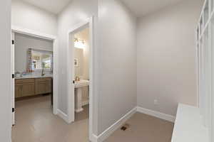 Corridor featuring light tile floors and two-tone paint