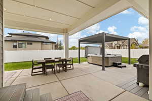 View of patio / terrace featuring outdoor dining area, a fenced backyard, and a hot tub