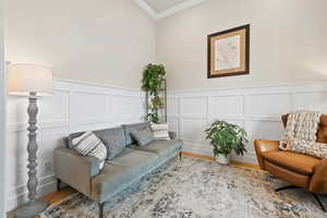 Font living area featuring light hardwood floors, a wainscoted wall, crown molding, and two-tone paint