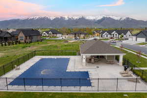 Community pool with fence, a patio area, and a residential view