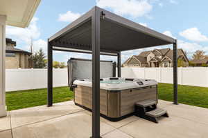 View of patio featuring a fenced backyard and a hot tub