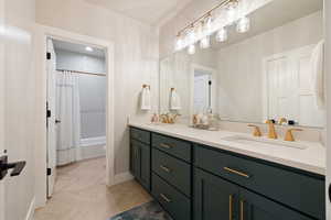 Full basement bathroom with tiled shower / bath combo, double vanity quartz countertops, two sinks, and gold fixtures