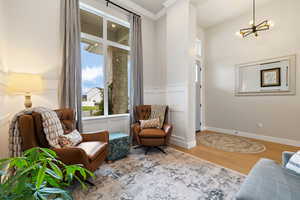 Font living area featuring light hardwood floors, a wainscoted wall, crown molding, and two-tone paint