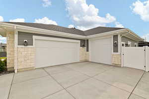 Single story home with roof with shingles, driveway, an attached garage, and stone siding