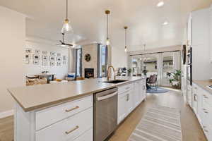 Open floorplan featuring kitchen with island, semi-formal dining space, and living room with stone fireplace