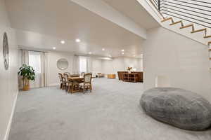 Carpeted open floorplan living space with two-tone paint and recessed lighting