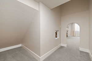 Under-stairs play space with carpeted flooring and two-tone paint