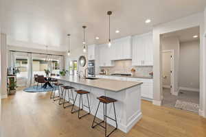 Kitchen featuring an island with quartz countertops, decorative backsplash, wall oven and gas cooktop
