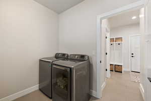 Laundry room featuring light tile flooring and washer and dryer