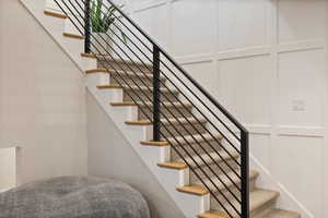 View of carpeted stairs with horizontal metal railing
