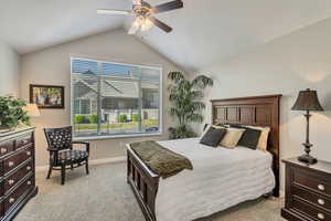 Bedroom featuring baseboards, ceiling fan, vaulted ceiling, and light colored carpet