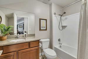 Bathroom with vanity, tile patterned floors, shower / bath combo, and toilet
