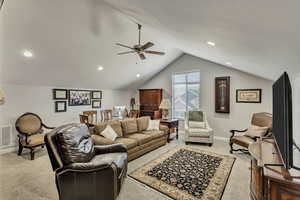 Living room with ceiling fan, baseboards, lofted ceiling, light carpet, and recessed lighting