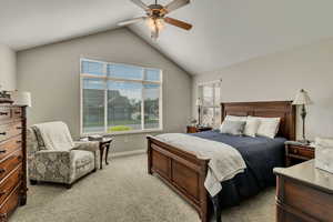 Bedroom with baseboards, light carpet, ceiling fan, and lofted ceiling