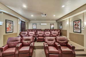 Carpeted home theater room with recessed lighting and a wall mounted AC
