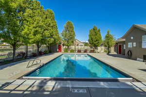 Community pool featuring a patio and fence