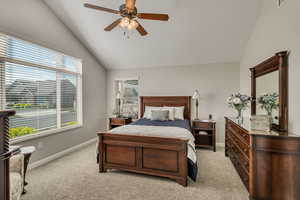 Bedroom featuring baseboards, light carpet, a ceiling fan, and lofted ceiling