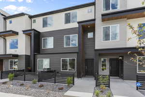 View of front of house featuring stucco siding and fence