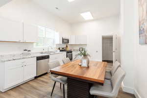 Dining space featuring visible vents, high vaulted ceiling, light wood-style flooring, and baseboards
