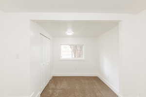 Spare room featuring baseboards and carpet floors
