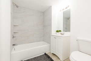 Bathroom featuring toilet, tub / shower combination, and vanity