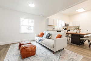 Living area featuring visible vents, light wood-type flooring, and baseboards