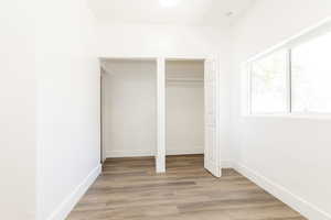 Unfurnished bedroom with baseboards, a closet, and light wood-style flooring