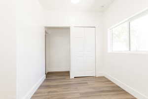 Unfurnished bedroom with baseboards, light wood-type flooring, and a closet