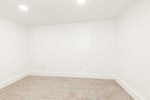 Unfurnished room with recessed lighting, baseboards, and light carpet