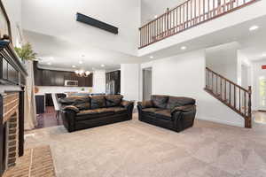 Living area featuring recessed lighting, a notable chandelier, light carpet, and stairway