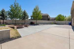 View of patio with a fenced backyard and a vegetable garden
