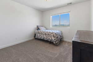 Bedroom with carpet floors, baseboards, and visible vents