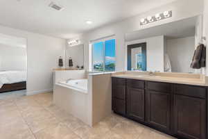 Full bathroom with a bath, visible vents, vanity, tile patterned floors, and ensuite bath