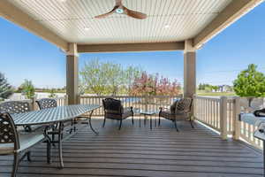 Wooden deck featuring a ceiling fan and outdoor dining area