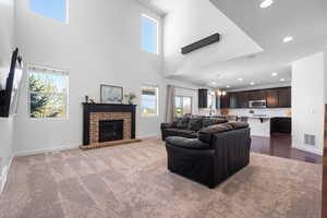 Carpeted living area with visible vents, recessed lighting, baseboards, and a chandelier