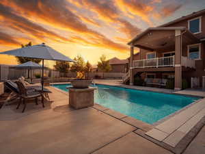 View of swimming pool with stairs, ceiling fan, a fenced backyard, a fenced in pool, and a patio area- Enhanced sunset