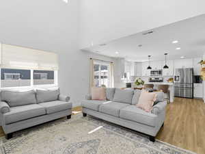 Living room with recessed lighting, visible vents, and light wood-style flooring