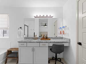 Master Bathroom with vanity, baseboards, a ceiling fan, and a garden tub