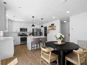 Dining room with recessed lighting, visible vents, and light wood-type flooring