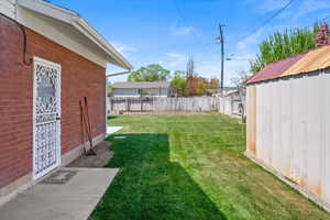 View of yard featuring an outbuilding, a fenced backyard, and a shed