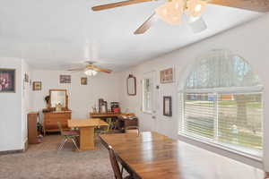 Dining area featuring ceiling fan and light colored carpet