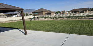 View of yard with a playground, a mountain view, and a patio area