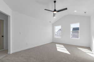 Unfurnished room with visible vents, baseboards, ceiling fan, carpet flooring, and vaulted ceiling