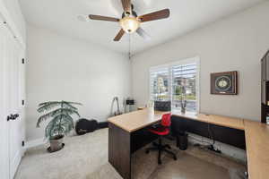 Home office featuring baseboards, a ceiling fan, and carpet floors