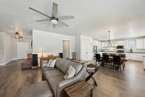 Living area with recessed lighting, hardwood / wood-style floors, baseboards, and ceiling fan with notable chandelier