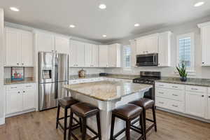 Kitchen featuring appliances with stainless steel finishes, a kitchen bar, plenty of natural light, and a kitchen island