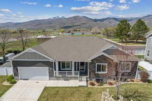 Ranch-style home with fence, covered porch, a mountain view, and an attached garage