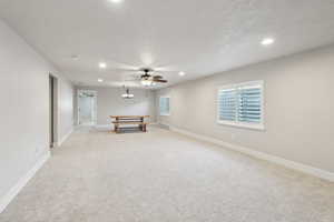 Rec room with light colored carpet, recessed lighting, a baseboard heating unit, and baseboards