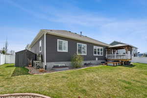 Rear view of house with a lawn, a storage shed, a gazebo, and a fenced backyard