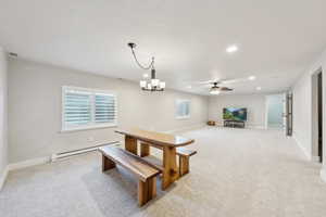 Dining area with light colored carpet, visible vents, baseboard heating, baseboards, and recessed lighting